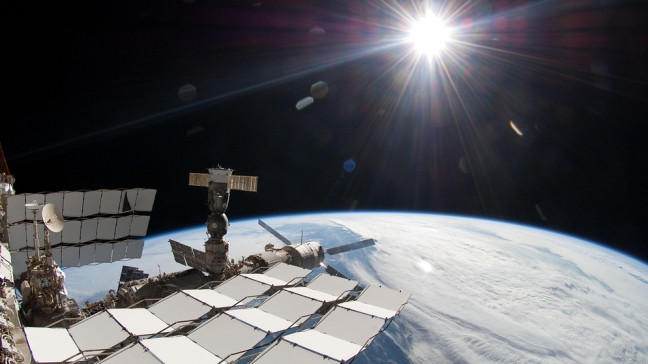 Die Sonne und ein Teil der ISS mit Blick auf die Erde | Bildquelle: picture alliance / dpa | NASA