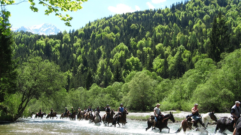 Reiter durchqueren die Loisach beim Alpenritt. Vom Kloster Andechs aus geht es über Schongau, Oberammergau, den Fernpass, Imst, den Reschenpass und durch den Vinschgau hindurch bis nach Meran. Der Alpenritt ist die Königsdisziplin der Wanderreiter. | Bildquelle: BR