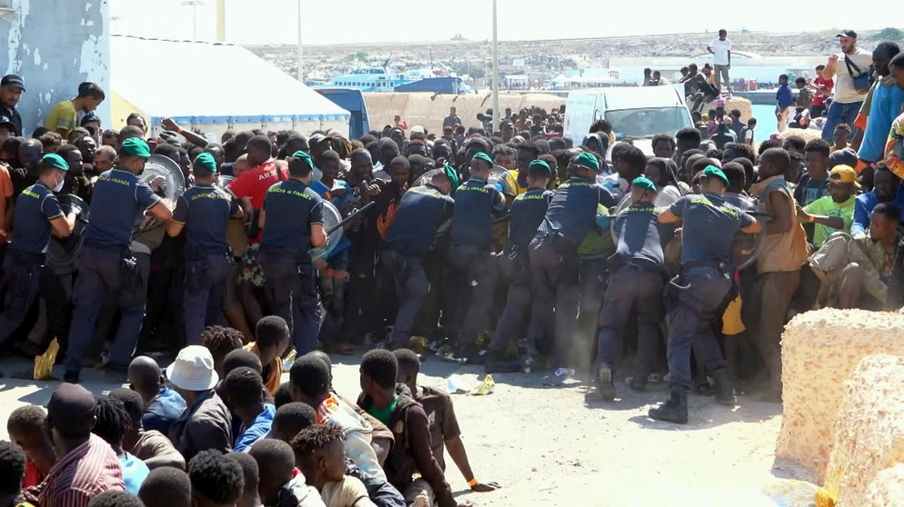 Beamte der Guardia di Finanza halten Flüchtlinge auf Lampedusa zurück. | Bildquelle: BR