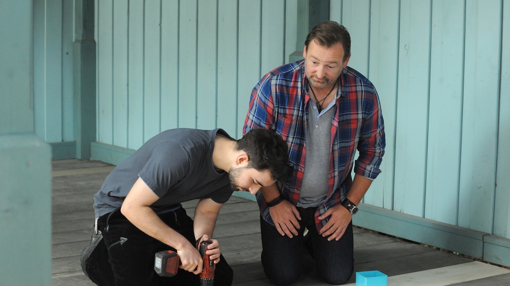 Dahoam is Dahoam: Felix (Shayan Hartmann, links) und Gregor (Holger Matthias Wilhelm, rechts) reparieren gemeinsam das Salettl. | Bildquelle: BR/Marco Orlando Pichler