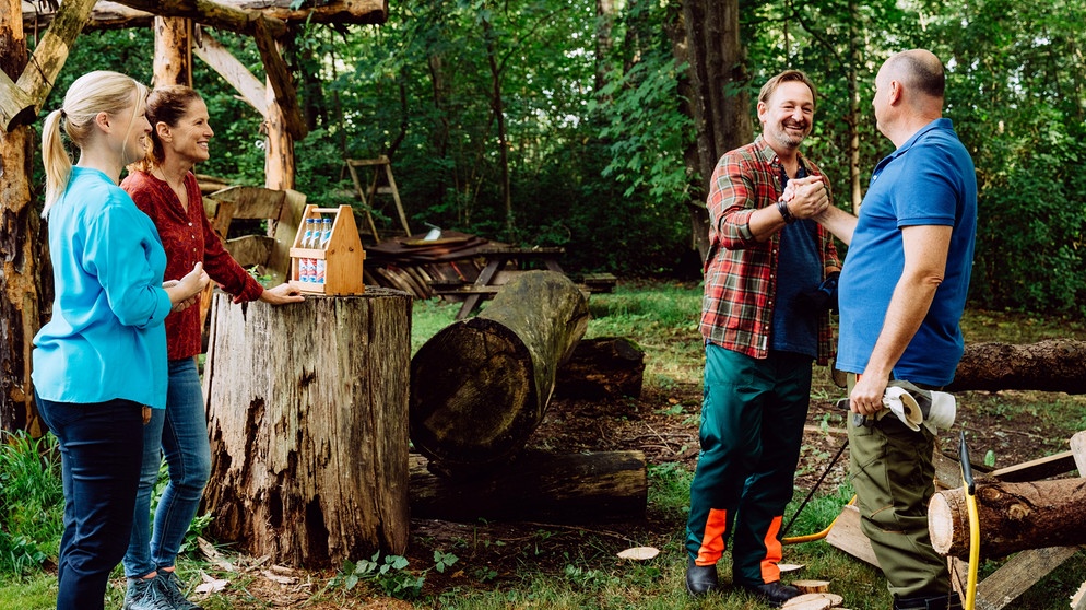 Dahoam is Dahoam: Gregor und Hubert treten im Ausscheidungskampf im Baumsägen gegeneinander an. Von links: Vera (Sybille Waury), Annalena (Heidrun Gärtner), Gregor (Holger Mathias Wilhelm), Hubert (Bernhard Ulrich). | Bildquelle: BR/Nadya Jakobs