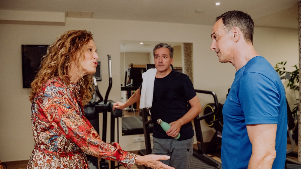 Dahoam is Dahoam: Mike (Harry Blank) und Annalena (Heidrun Gärtner) streiten, weil Mike ihr romantisches Dinner vergessen hat. Im Hintergrund: Hotelgast Herbert Bock (Fritz Barth). | Bildquelle: BR/Nadya Jakobs