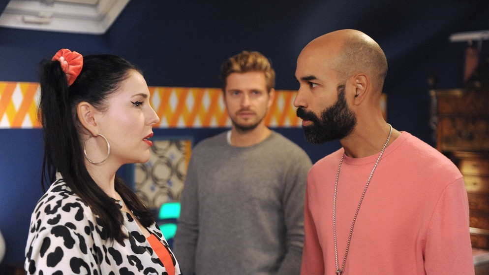 Dahoam is Dahoam: Naveen macht Tina klar, dass er nicht eifersüchtig auf Lasse ist, als dieser den Raum betritt. Von links: Tina (Anita Eichhorn), Lasse (Jörn Schlönvoigt),  Markus (Markus Subramaniam). | Bildquelle: BR/Marco Orlando Pichler