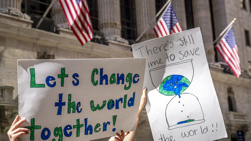 alpha-demokratie - Die USA und der Umweltschutz / Jugendliche mit Plakat vor der New Yorker Börse | Bildquelle: picture-alliance/dpa