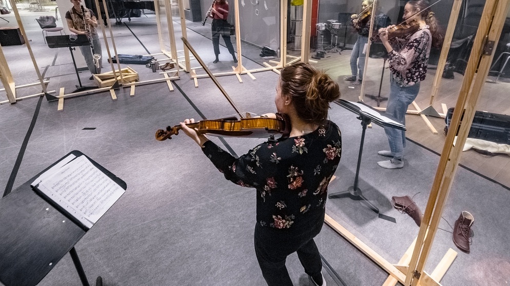 Mitglieder des Klezmer-Ensembles "Vagabund" der Musikhochschule Lübeck proben, durch Plexiglasschutzwände voneinander getrennt, in einem leerstehenden Modegeschäft in Lübecks Innenstadt.  | Bildquelle: picture-alliance/dpa