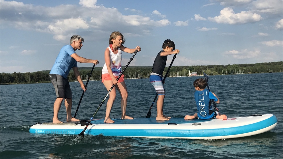 Stand Up Paddling als Belohnung am Abend: Wenn der Trubel an der Wasserski- und Wakeboard-Anlage vorbei ist, beginnen die Stunden mit der Familie auf dem Wasser. | Bildquelle: BR/Dominique Klughammer