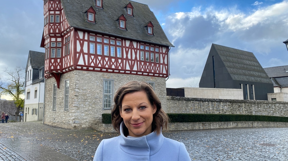 Moderatorin Irene Esmann vor dem Bischofshaus in Limburg an der Lahn, das vor zehn Jahren für viele Schlagzeilen gesorgt hat, weil es deutlich teurer wurde, unter anderem wegen extravaganten Wünschen des damaligen Bischofs Franz-Peter Tebartz-van Elst.  | Bildquelle: BR/Christian Wölfel