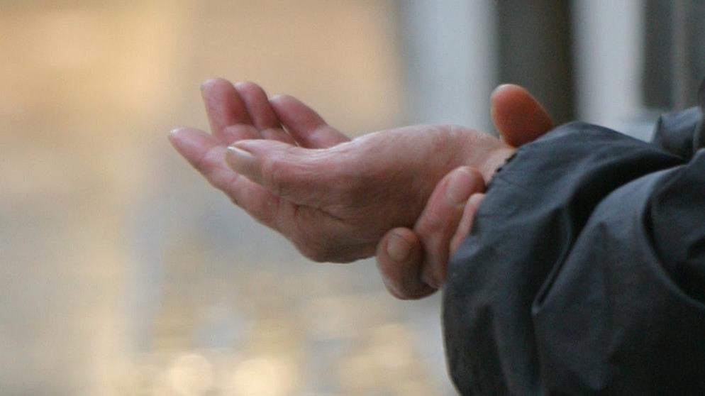 Ein Bettler streckt die Hand aus | Bildquelle: picture-alliance/dpa