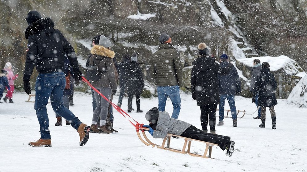 Ein Junge lässt sich auf seinem Schlitten durch den Schnee ziehen. | Bildquelle: dpa-Bildfunnk