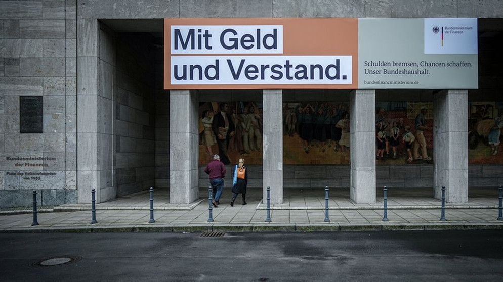 Ein Plakat mit der Aufschrift "Mit Geld und Verstand. Schulden bremsen, Chancen schaffen. Unser Bundeshaushalt." hängt über dem Eingang zum Bundesministerium der Finanzen in Berlin. | Bildquelle: dpa-Bildfunk/Kay Nietfeld