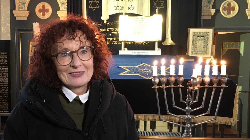 Anna Zisler vor dem Chanukka-Leuchter in der Straubinger Synagoge. | Bildquelle: BR/Evelyn Schels