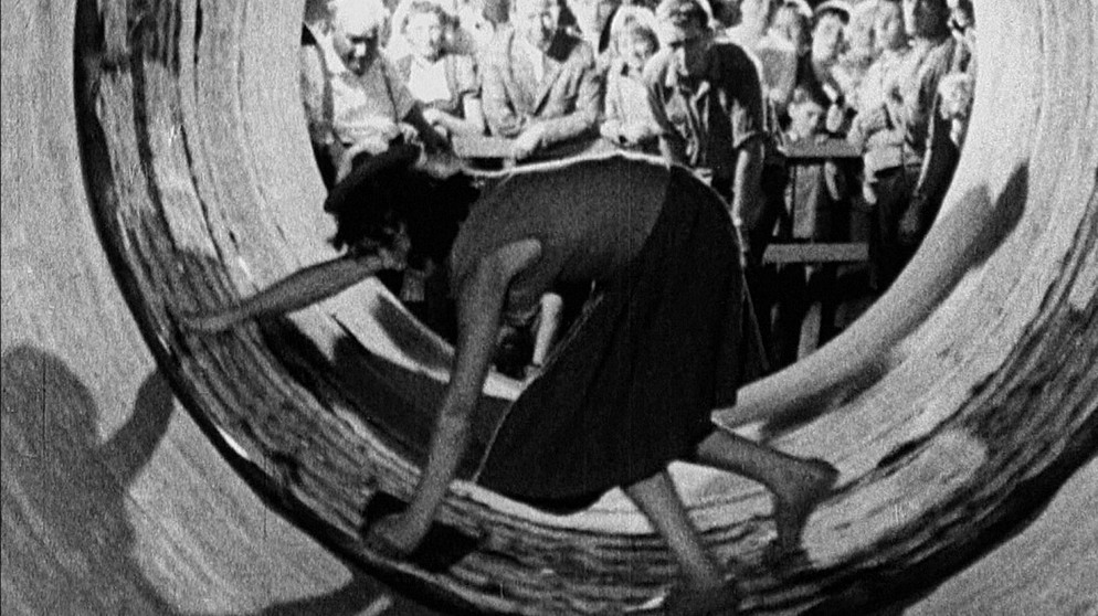 Oktoberfest in München 1959 - eine Frau zieht interessierte Blicke auf sich. | Bildquelle: BR