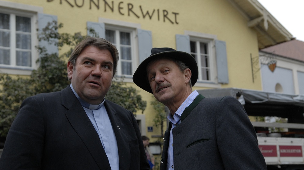 Pfarrer Neuner und Bürgermeister Schattenhofer freuen sich über eine scheinbare Bierlieferung der Kirchleitners an den Brunnerwirt. Von links: Pfarrer Neuner (Peter Rappenglück) und Lorenz Schattenhofer (Werner Rom). | Bildquelle: BR/Marco Orlando Pichler
