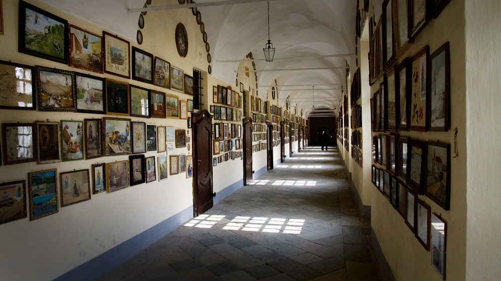 Votivbilder und Gaben hängen an den Wänden der Flure in der Wallfahrtskirche von Oropa. | Bildquelle: BR/SWR