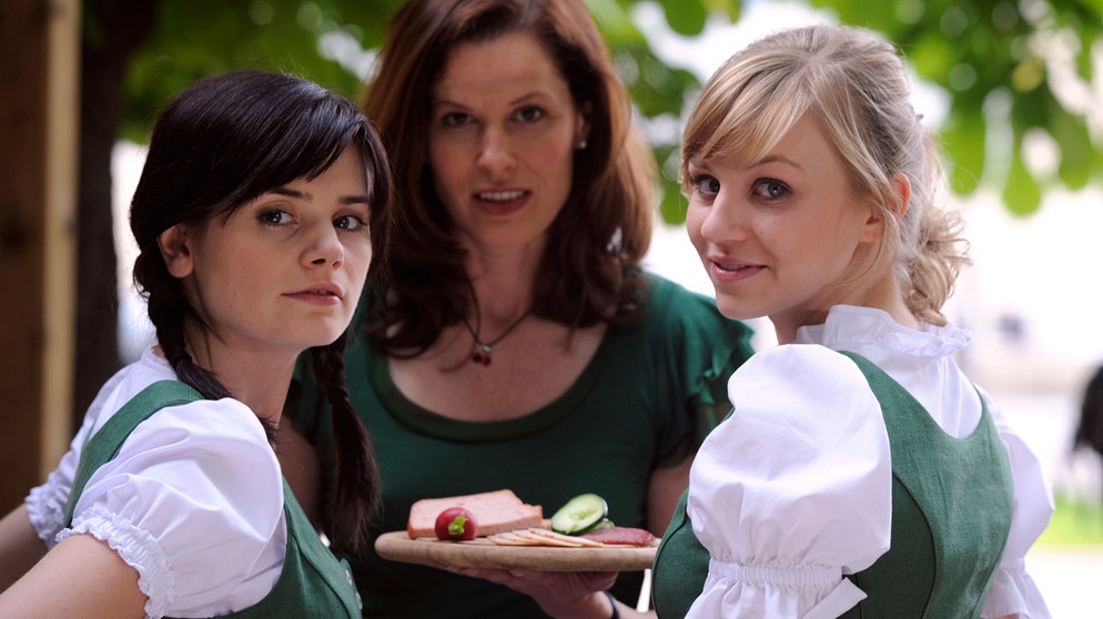 Saskia will Annalena mit Sebastian verkuppeln. Von links: Saskia (Joyce Ilg), Annalena Brunner (Heidrun Gärtner) und Caro Ertl (Teresa Rizos). | Bildquelle: BR/Marco Orlando Pichler