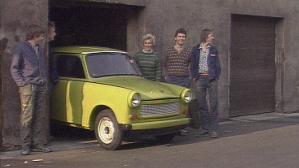 Der Trabant 601, gebaut in Zwickau und im Volksmund liebevoll "Trabi" genannt, war der Volks-Wagen der DDR. Wer einen haben wollte, musste 14 Jahre warten. Im Bild: eine stolze Familie mit ihrem Gefährt im November 1989. | Bildquelle: BR/NDR