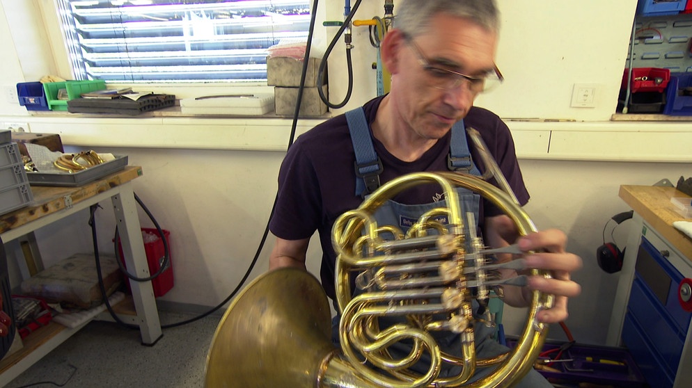 Blasinstrumentenbauer Eckard Graf prüft das von ihm gebaute Horn. | Bildquelle: SWR