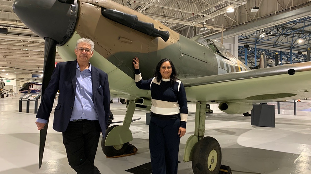 Presenterin Raksha Dave mit dem renommierten Historiker Dilip Sarkar vor einem "Spitfire"-Jagdflugzeug im Museum der Royal Air Force im Londoner Stadtteil Hendon im Norden der britischen Hauptstadt. | Bildquelle: BBC/Voltage TV Productions Ltd
