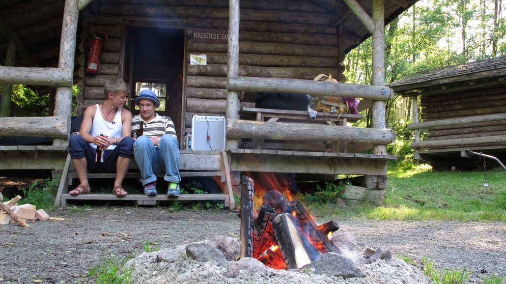Zu Beginn der zweiten Sendung hat Moderator Sam (rechts) eine Überraschung für Jesper Munk (links) und seine Band parat: Camping im Wilden Westen alias Pullman City in Niederbayern! | Bildquelle: Honorarfrei lediglich für Ankündigungen und Veröffentlichungen im Zusammenhang mit obiger BR-Sendung bei Nennung: Bild: BR/Johanna Zach. Die Nutzung im Social Media-Bereich, sowie inhaltlich andere Verwendungen nur nach vorheriger schriftlicher Vereinbarung mit dem BR-Bildarchiv, Tel. 089 / 5900 10580, Fax 089 / 5900 10585, Mail Pressestelle.foto@br.de