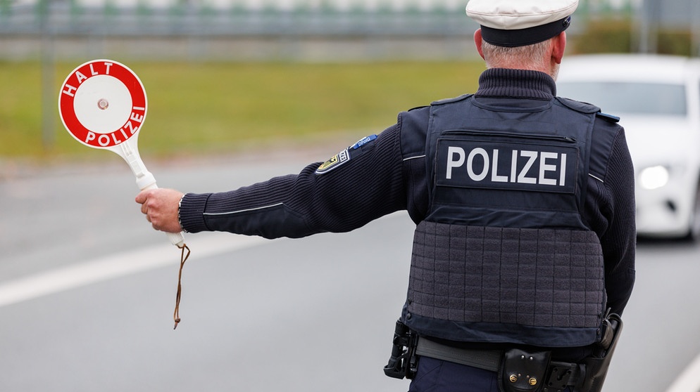 ARCHIV - 18.10.2023, Bayern, Furth im Wald: Ein Beamter der Bundespolizei stoppt bei der Kontrolle des Einreiseverkehrs am deutsch-tschechischen Grenzübergang Furth im Wald - Ceska Kubice den Fahrer eines Autos bei der Einreise. (zu dpa: «Schlag gegen mutmaßliche Schleuserbande - drei Festnahmen») Foto: Daniel Karmann/dpa +++ dpa-Bildfunk +++ | Bildquelle: dpa-Bildfunk/Daniel Karmann