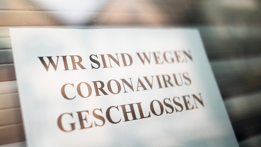 Schild in einem Ladenfenster auf dem steht "Wir sind wegen Coronavirus geschlossen" | Bildquelle: picture-alliance/dpa/Christoph Schmidt