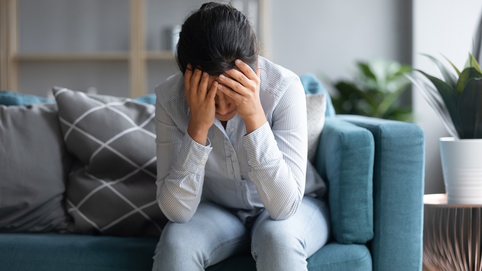 Frau hält ihren Kopf, ist erschöpft, kraftlos, Kopfschmerzen. Chronic Fatigue Syndrom kann eine Langzeitfolge von Covid-19 sein. | Bildquelle: colourbox.com