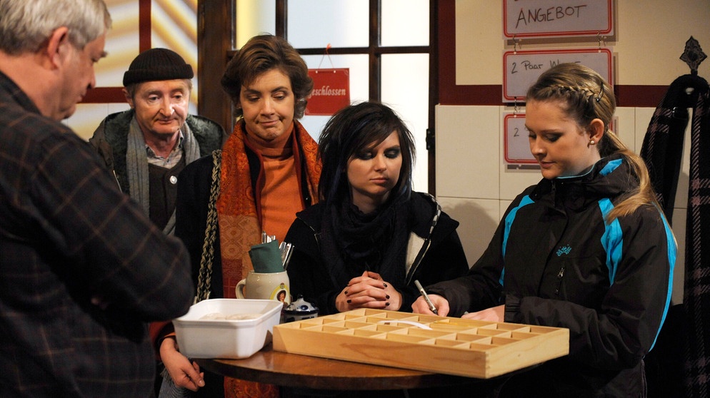 Yvonne und Nina nehmen die Bestellungen für ihre Glücksnüsse entgegen. Von links: Joseph Brunner (Wilhelm Manske), Xaver (Michael Schreiner), Maria Kirchleitner (Daniela März), Nina Kreutzer (Andrea Schmitt) und Yvonne Preissinger (Alexa Eilers). | Bildquelle: BR/Marco Orlando Pichler
