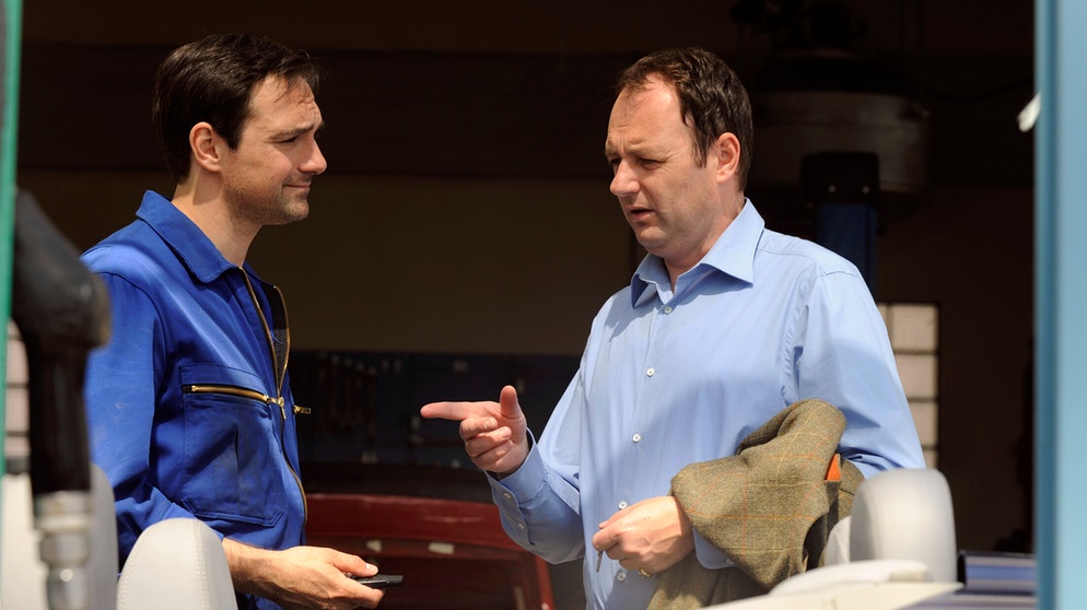 Dahoam is Dahoam. Hubert gibt seinen Wagen zur Reparatur. Von links: Mike Preissinger (Harry Blank) und Hubert Kirchleitner (Bernhard Ulrich). | Bildquelle: BR/Marco Orlando Pichler
