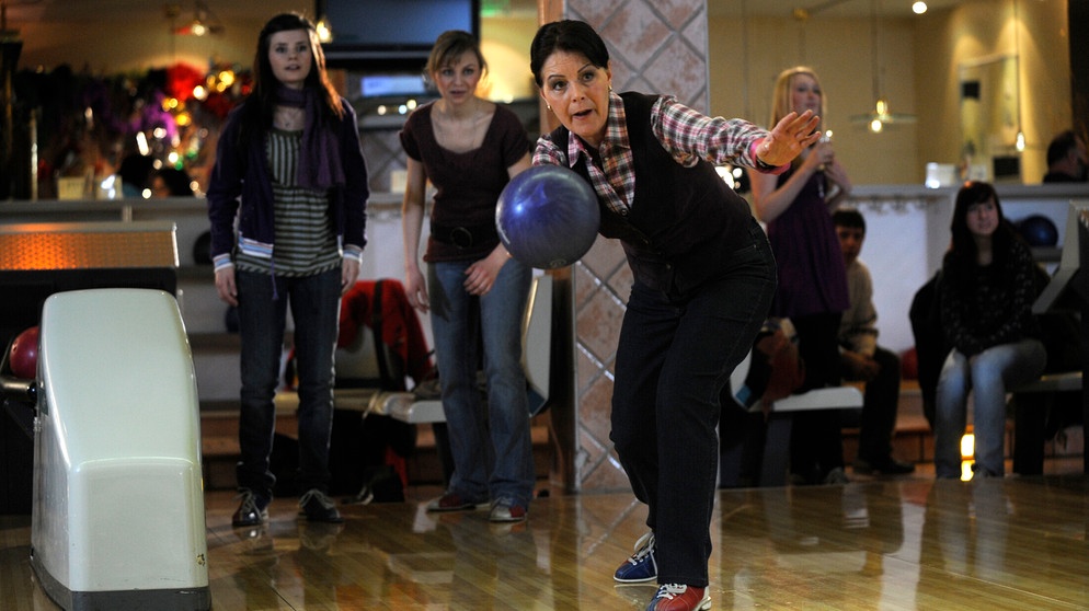 Rosi versucht sich auf der Bowlingbahn. Von links: Saskia Brunner (Joyce Ilg), Caro Ertl (Teresa Rizos) und Rosi Brunner (Brigitte Walbrun). | Bildquelle: BR/ Marco Orlando Pichler
