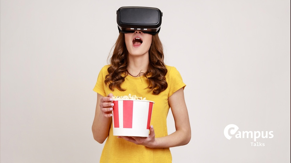 Junge Frau in gelbem T-Shirt mit virtueller Brille und Popcorn essend mit Campus Logo | Bildquelle: picture alliance / Zoonar | khosro Rajabkordi