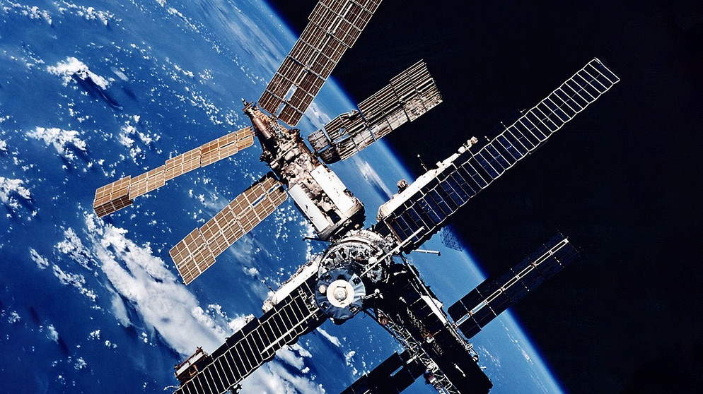 Die damalige russische Raumstation «Mir» mit der Erde im Hintergrund aufgenommen von der Raumfähre Atlantis. Foto: NASA/dpa  | Bildquelle: dpa-Bildfunk