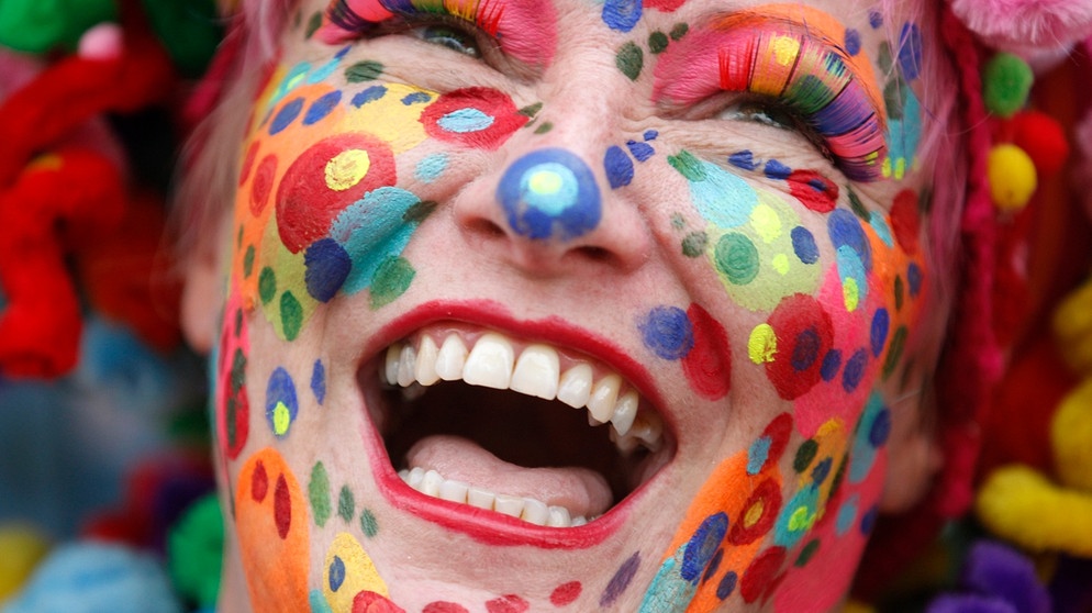 Im Bild: geschminkte Frau im Kölner Karneval. Fasching, Fastnacht oder Karneval - die Begriffe werden je nach Region verwendet. Sprachwissenschaftler haben die Bedeutung der Begriffe untersucht.  | Bildquelle: picture alliance / dpa | Roland Weihrauch