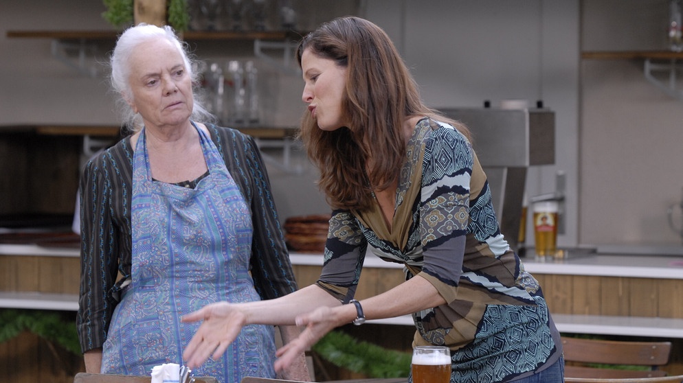 Dahoam is Dahoam: Theresa Brunner ist eingeschnappt. Sie kann ihrer Enkelin Annalena nicht verzeihen, dass diese vor 17 Jahren Lansing verlassen hat. Von links: Theresa Brunner (Ursula Erber) und Annalena (Heidrun Gärtner). | Bildquelle: BR/Marco Orlando Pichler