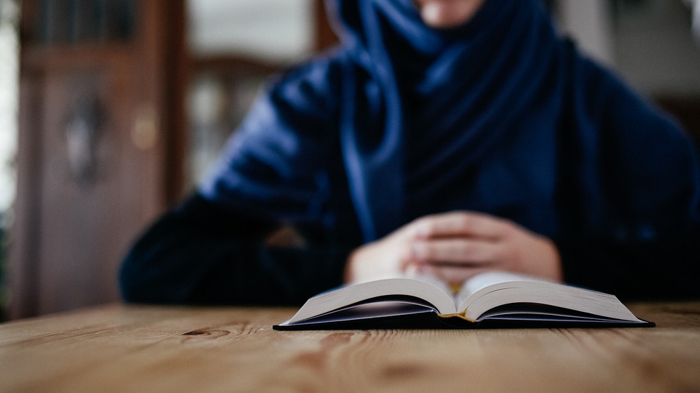 Eine Frau liest im Koran. | Bildquelle: BR/Julia Müller