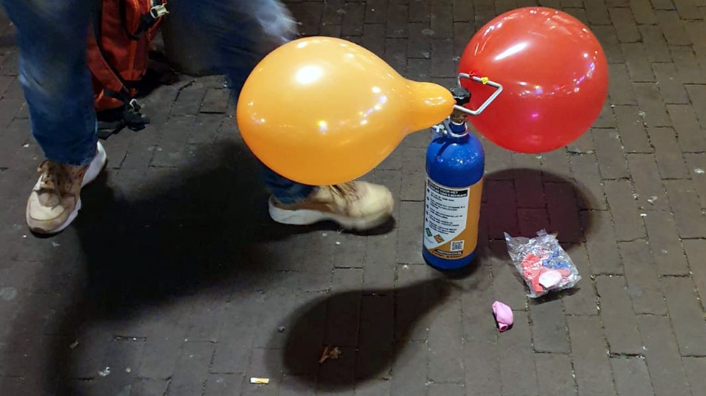 Eine Person konsumiert Lachgas über einen Luftballon | Bildquelle: picture alliance/dpa | Annette Birschel