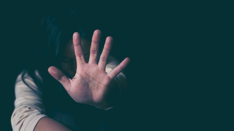 Eine Frau macht eine wehrhafte Geste, die symbolisch für Gewalt gegen Frauen steht. | Bildquelle: stock.adobe.com/doidam10