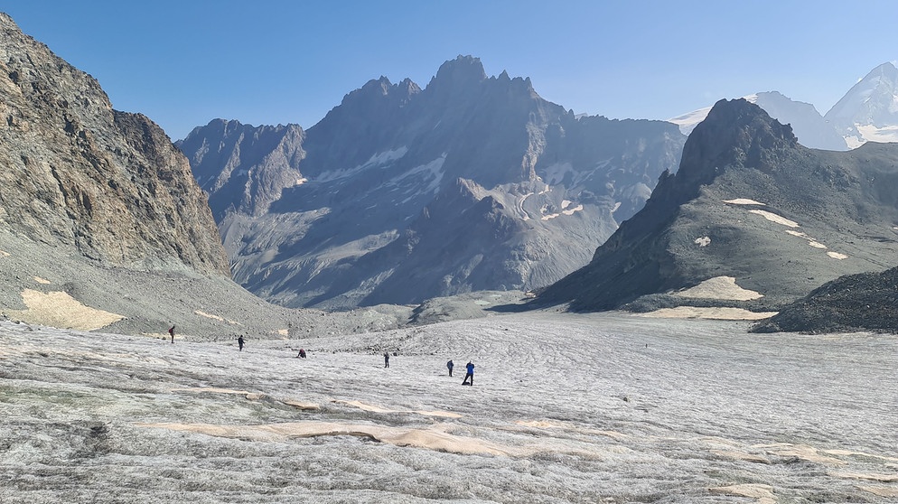 Flacher Gletscher mit Menschen und Bergen im Hintergrund | Bildquelle: BR/Sebastian Kirchner