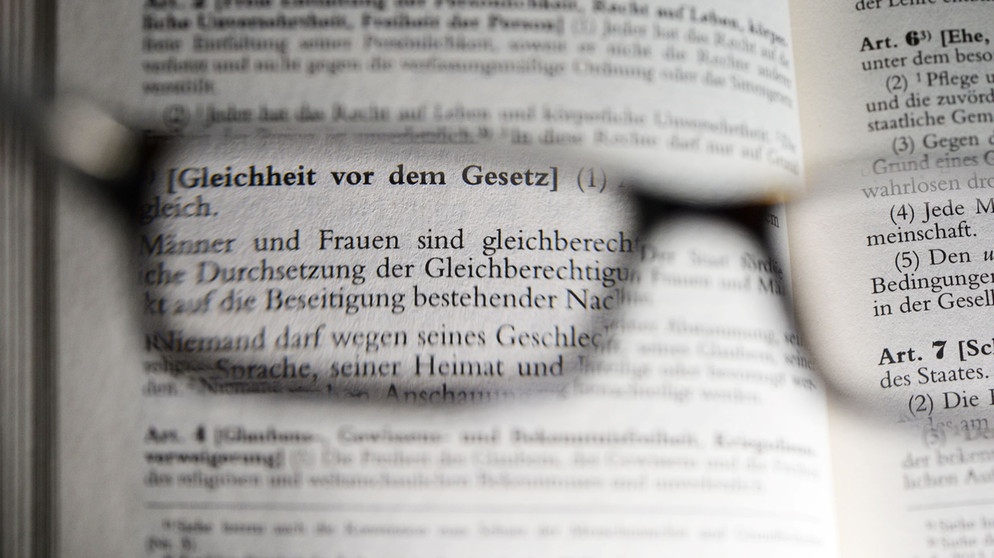 Der Artikel 3 des Grundgesetzes über Gleichheit vor dem Gesetz, fotografiert am 04.11.2015 in Berlin durch eine Brille. | Bildquelle: picture alliance / ZB | Jens Kalaene