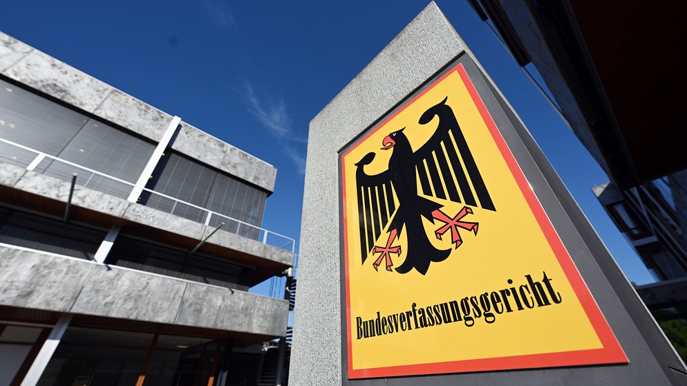 Ein Hinweisschild mit Bundesadler und dem Schriftzug «Bundesverfassungsgericht», aufgenommen vor dem Bundesverfassungsgericht.  | Bildquelle: dpa-Bildfunk/Uli Deck