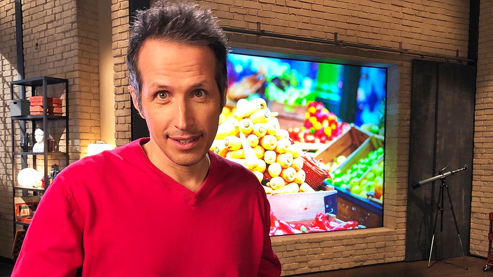 "Gut zu wissen"-Moderator Willi Weitzel. Hintergrund ein Bild mit Gemüse. Was kosten Lebensmittel wirklich?  | Bildquelle: BR/Gut zu wissen