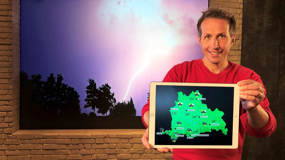Willi Weitzel mit Wetter-App und Gewitterstimmung im Hintergrund. Bessere Vorhersage bei Starkregen | Bildquelle: BR/Gut zu wissen