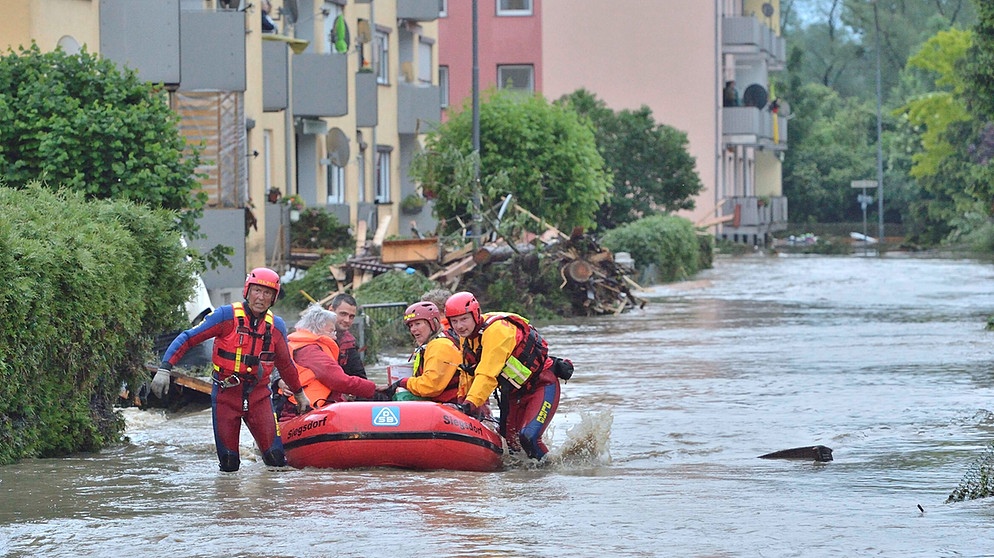 Mitarbeiterinnen der Wasserwacht ziehen am 01.06.2016 in Simbach am Inn (Landkreis Rottal-Inn) ein Schlauchboot durch das Hochwasser. | Bildquelle: picture alliance / abaca | AA