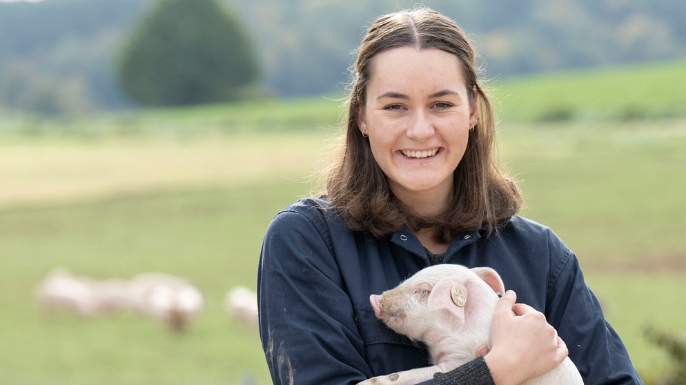 Kathi Mühlbauer auf dem Kirchthanner Biohof in Postau mit einem Ferkel auf dem Arm. | Bildquelle: WDR/Melanie Grande