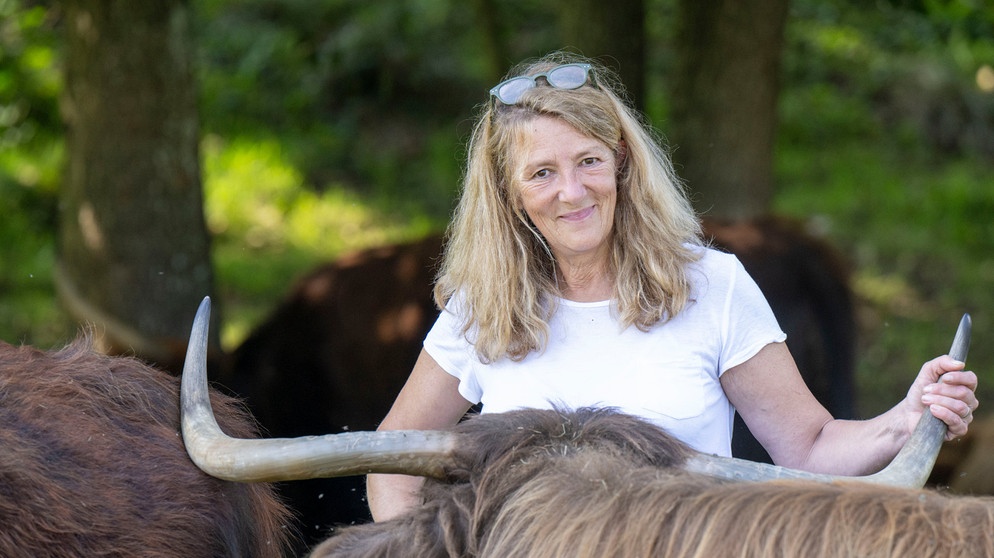 Christine Baumann auf der Weide vom Biohof Baumann bei ihren Schottischen Hochlandrindern im Schwarzwald. | Bildquelle: WDR/Melanie Grande