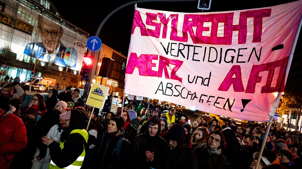 dpatopbilder - 29.01.2025, Berlin: Menschen nehmen an der Kundgebung «Brandmauer statt Brandstiftung» von Amnesty International, Seebrücke und anderen Organisationen mit einem Banner mit der Aufschrift «Asylrecht verteidigen Merz und AfD abschaffen» vor der CDU Zentrale teil. Foto: Fabian Sommer/dpa +++ dpa-Bildfunk +++ | Bildquelle: dpa-Bildfunk/Fabian Sommer