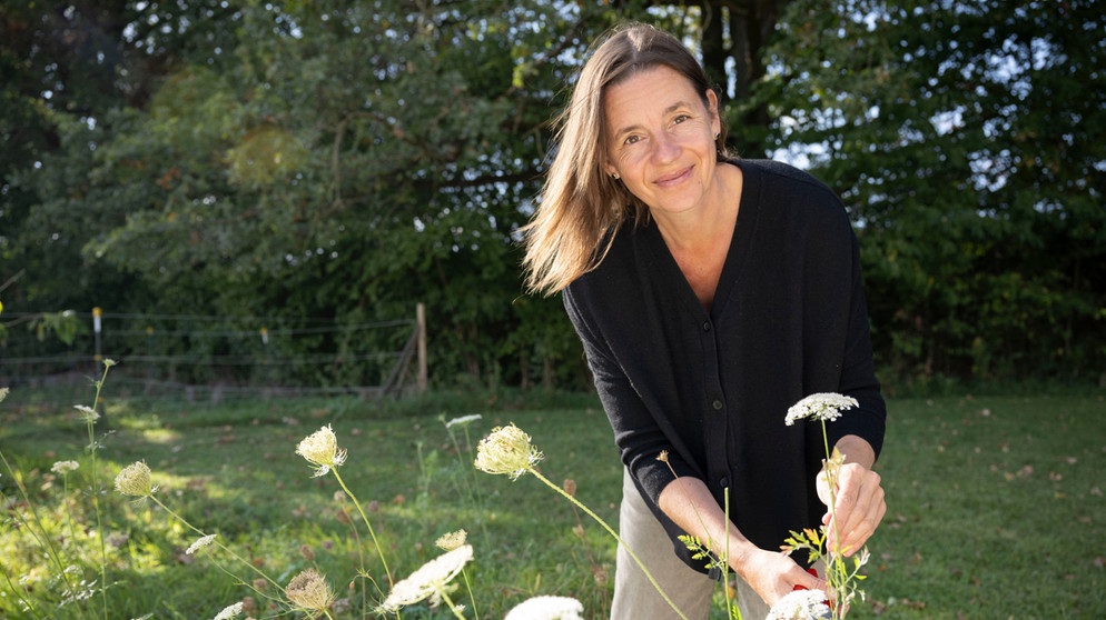 Christine Huber auf dem Kreuthof in Puchheim pflückt Schafgarbenblüten für die Schafgarbenbutter im Gruß aus der Küche. | Bildquelle: WDR/Melanie Grande