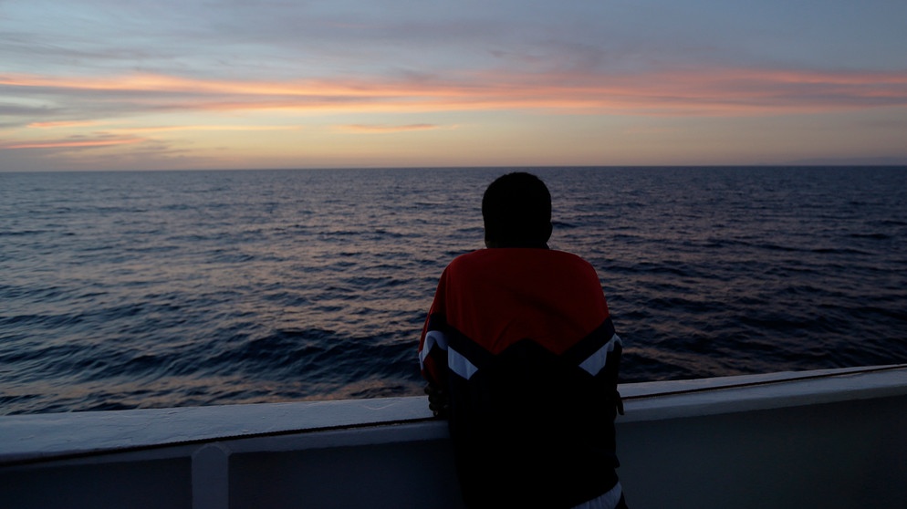 Mann schaut auf das Meer | Bildquelle: picture alliance / ASSOCIATED PRESS | Luca Bruno