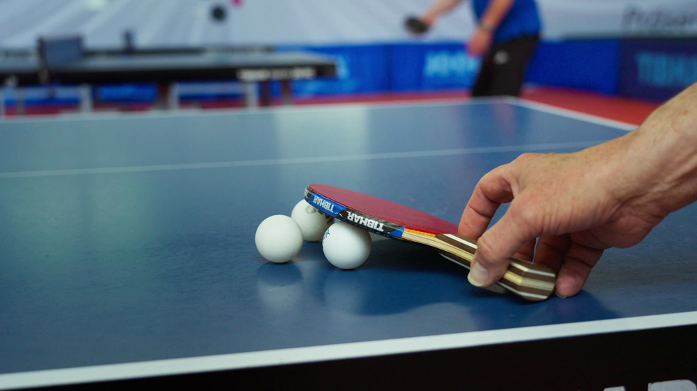 Hand greift nach Tischtennisschläger | Bildquelle: BR