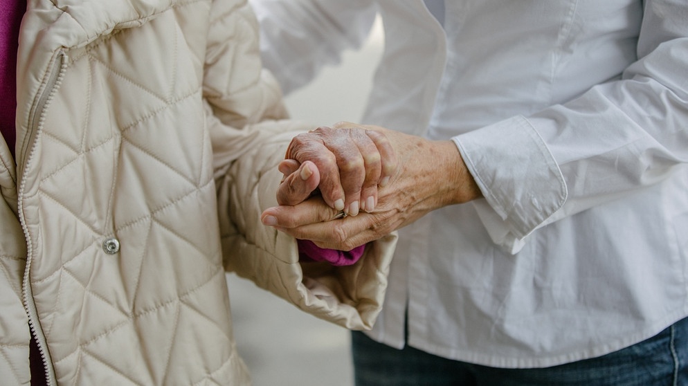 Eine Pflegerin stützt eine Seniorin. | Bildquelle: BR/Johanna Schlüter