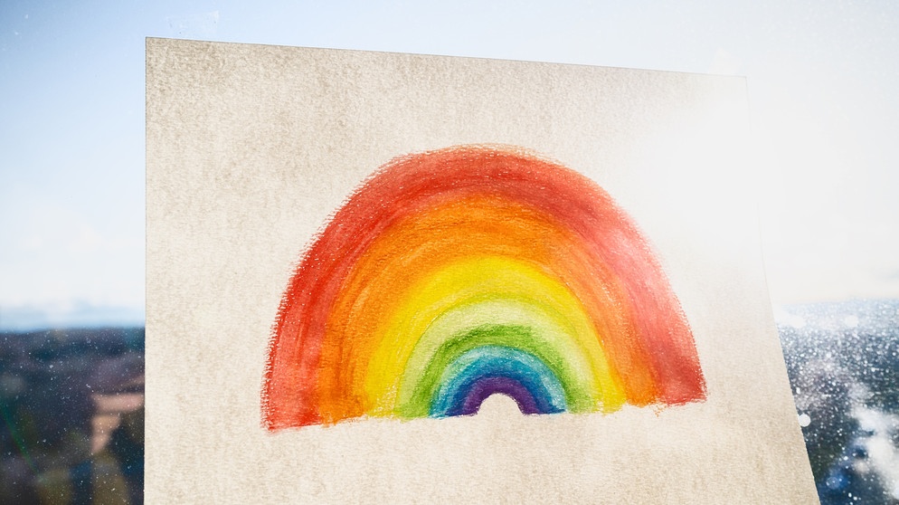 Ein gemalter Regenbogen vor einem regnerischen Fenster. Die Mehrheit der Menschen in Europa sehen die Zukunft ihres Landes eher pessimistisch. Gleichzeitig sehen aber 80 Prozent der Menschen ihre eigene Zukunft optimistisch. Wie passen der Widerspruch von Optimismus und Pessimismus zusammen? | Bildquelle: colourbox.com